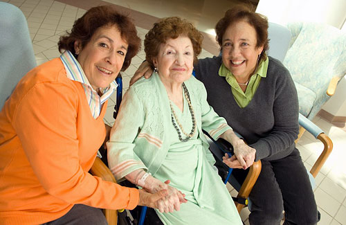 Mother holding hands with two daughters on each side, in the atrium of the Friedman Pavilion