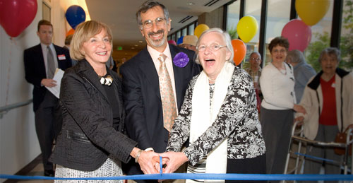 Three community leaders cutting the ribbon at the opening celebration