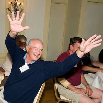 Man in dining room, arms raised in the air