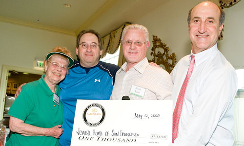four people at a fundraiser check presentation
