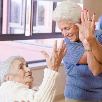 Volunteer shows a yoga position to a resident