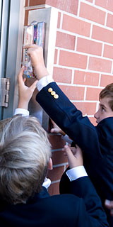 Two boys hanging a mezuzah